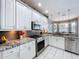 Bright kitchen features white cabinets, granite countertops, stainless appliances, and neutral backsplash at 1218 Willow Bend Way, Lutz, FL 33549