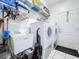 Bright laundry room with utility sink, washer, dryer, shelving, and access to the rear at 1218 Willow Bend Way, Lutz, FL 33549