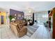 Living room with tile flooring, sofas, and sliding glass doors to the screened pool area at 1218 Willow Bend Way, Lutz, FL 33549