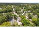 Aerial shot of a house surrounded by mature trees, featuring a large backyard with a seating area at 1226 E Henry Ave, Tampa, FL 33604