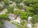 Aerial view of a property with lush greenery, a fenced backyard, and a detached garage, showcasing its serene setting at 1226 E Henry Ave, Tampa, FL 33604