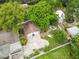 Aerial view of a property with a two-car garage, fenced backyard, and mature trees, offering privacy and space at 1226 E Henry Ave, Tampa, FL 33604