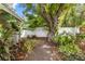 Lush backyard with a serene gravel path surrounded by tropical plants and trees, offering a peaceful outdoor retreat at 1226 E Henry Ave, Tampa, FL 33604