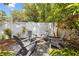 Charming backyard featuring a cozy fire pit area with Adirondack chairs and string lights, perfect for outdoor gatherings at 1226 E Henry Ave, Tampa, FL 33604