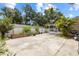Spacious backyard with mature trees, a white fence, a detached garage, and a screened porch at 1226 E Henry Ave, Tampa, FL 33604