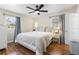 Bedroom with hardwood floors, a ceiling fan, two windows, and a bed with white linens at 1226 E Henry Ave, Tampa, FL 33604