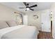 Bedroom with hardwood floors, a ceiling fan, two windows, and a bed with white linens at 1226 E Henry Ave, Tampa, FL 33604