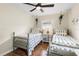 Bright bedroom with two beds, ceiling fan and hanging plants near window at 1226 E Henry Ave, Tampa, FL 33604