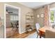 Dining room adjacent to second living area with stylish shelving and light-filled window at 1226 E Henry Ave, Tampa, FL 33604