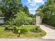 Charming home with a well-manicured lawn, flowerbeds, and a long driveway leading to a brick chimney at 1226 E Henry Ave, Tampa, FL 33604
