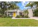 Charming single-story home with a bright yellow door and well-manicured landscaping at 1226 E Henry Ave, Tampa, FL 33604