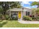 Lovely home with a bright yellow front door and lush landscaping at 1226 E Henry Ave, Tampa, FL 33604