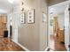 Hallway leading to sunlit bedroom with hardwood floors and decorative pictures on the wall at 1226 E Henry Ave, Tampa, FL 33604