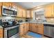 Updated kitchen with stainless steel appliances, granite countertops, wood cabinets, and stylish backsplash at 1226 E Henry Ave, Tampa, FL 33604