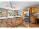 Eat-in kitchen with wood cabinets, granite countertops, stainless steel appliances, and center island with pendant lighting at 1226 E Henry Ave, Tampa, FL 33604