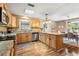 Bright kitchen featuring granite countertops, stainless steel appliances, wood cabinets, and center island with pendant lighting at 1226 E Henry Ave, Tampa, FL 33604