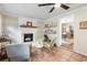 Comfortable living room featuring a whitewashed fireplace, stylish decor, and adjacent dining space at 1226 E Henry Ave, Tampa, FL 33604