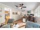 Bright home office featuring two chairs, ceiling fan, and desk setup with dual monitors, and the kitchen can be seen in the background at 1226 E Henry Ave, Tampa, FL 33604