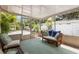 Inviting screened-in lanai featuring cozy seating and a serene view of the lush backyard at 1226 E Henry Ave, Tampa, FL 33604