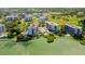 Scenic aerial view of waterfront apartments featuring pools, lush greenery, and serene water views, creating a tranquil living environment at 125 Belleview Boulevard # 203, Belleair, FL 33756