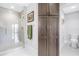 Bright bathroom with large glass shower, spacious linen closet, and white tiled floors at 125 Belleview Boulevard # 203, Belleair, FL 33756