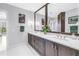 Bathroom featuring double vanity, a large mirror and decorative accents at 125 Belleview Boulevard # 203, Belleair, FL 33756