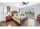 Comfortable bedroom with hardwood floors, king bed, fan, and a large glass sliding door at 125 Belleview Boulevard # 203, Belleair, FL 33756