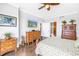 Bright bedroom with hardwood floors, fan, and view of the ensuite bathroom at 125 Belleview Boulevard # 203, Belleair, FL 33756