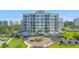 Luxury condominium showcasing lush landscaping, circular driveway, and coastal architecture, embodying upscale community living at 125 Belleview Boulevard # 203, Belleair, FL 33756