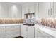Modern kitchen with white cabinets, quartz countertops, and a unique mosaic backsplash at 125 Belleview Boulevard # 203, Belleair, FL 33756