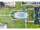 Aerial view of a community pool surrounded by palm trees and lush green landscaping at 125 Belleview Boulevard # 203, Belleair, FL 33756