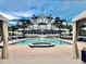 Stunning resort-style pool and spa with an elegant white building backdrop and palm trees on a partly cloudy day at 125 Belleview Boulevard # 203, Belleair, FL 33756