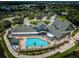 Overhead view of the clubhouse with a large pool, jacuzzi, palm trees, and ample lounge seating at 1338 Winding Willow Dr, Trinity, FL 34655
