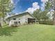 Well-maintained backyard featuring a screened-in lanai, lush lawn, and mature landscaping at 1338 Winding Willow Dr, Trinity, FL 34655