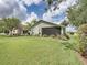 Expansive backyard with lush lawn, mature landscaping, and a screened lanai overlooking the scenic property at 1338 Winding Willow Dr, Trinity, FL 34655