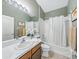 Neutral bathroom featuring a shower-tub combination and vanity with a white countertop and a large mirror at 1338 Winding Willow Dr, Trinity, FL 34655