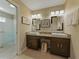 Bright bathroom with dual sinks, granite countertops, modern lighting, and glass door shower at 1338 Winding Willow Dr, Trinity, FL 34655