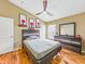 Bedroom with wood laminate flooring, ceiling fan and queen size bed with modern headboard and dresser at 1338 Winding Willow Dr, Trinity, FL 34655