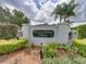 Community sign for Winding Willow Village with lush landscaping and American flags at 1338 Winding Willow Dr, Trinity, FL 34655