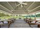 Spacious covered pavilion featuring picnic tables, a grill, and overhead fans for comfortable outdoor gatherings at 1338 Winding Willow Dr, Trinity, FL 34655