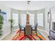 Stylish dining area offers ample natural light with colorful rug, adjacent to an open kitchen at 1338 Winding Willow Dr, Trinity, FL 34655