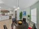 Bright dining area featuring a round table with black chairs, modern lighting, and a view to the kitchen at 1338 Winding Willow Dr, Trinity, FL 34655