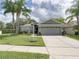 Charming single-story home with a well-manicured lawn and mature palm trees at 1338 Winding Willow Dr, Trinity, FL 34655