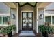 Elegant double front door with decorative glass, flanked by potted plants and stylish outdoor lighting at 1338 Winding Willow Dr, Trinity, FL 34655