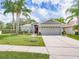 Inviting single-story home with beautiful landscaping, a well-maintained lawn, and an attached garage at 1338 Winding Willow Dr, Trinity, FL 34655