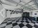 Spacious garage with a checkered floor and custom wall art, providing ample room for parking and storage at 1338 Winding Willow Dr, Trinity, FL 34655