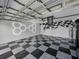 Spacious garage with a checkered floor and custom wall art, providing ample room for parking and storage at 1338 Winding Willow Dr, Trinity, FL 34655