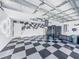 Spacious garage features a checkered tile floor, racing-themed decor, and ample room for storage at 1338 Winding Willow Dr, Trinity, FL 34655