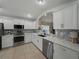 Modern kitchen featuring white cabinets, stainless steel appliances, and granite countertops at 1338 Winding Willow Dr, Trinity, FL 34655