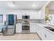 Contemporary kitchen boasts stainless steel appliances, white cabinets, and mosaic tile backsplash at 1338 Winding Willow Dr, Trinity, FL 34655